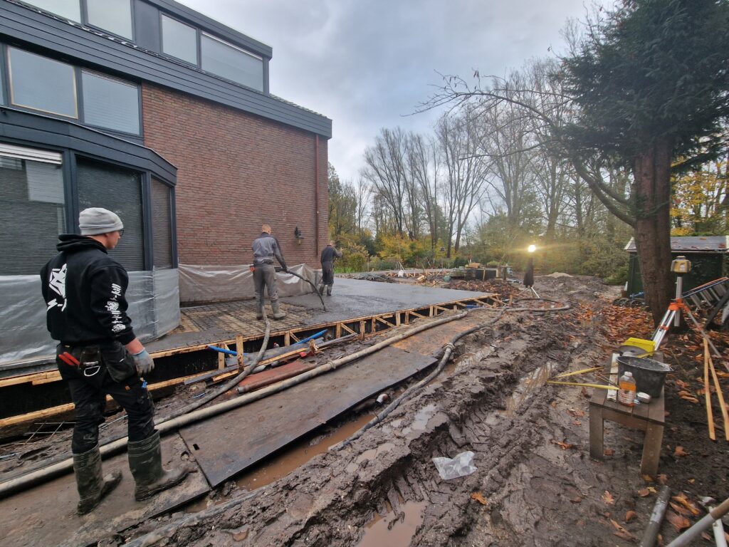 Vakmannen van Betonbaas zijn bezig met het aanbrengen van beton voor een terras