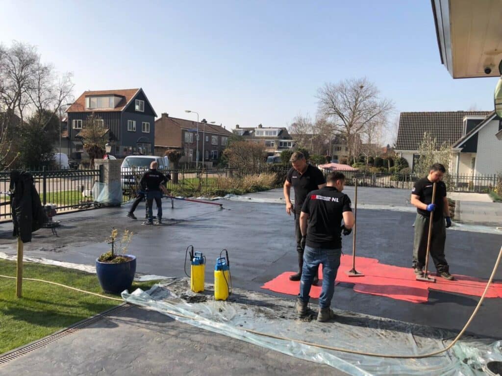 Werkmannen zijn druk bezig met het aanleggen van een betonnen oprit