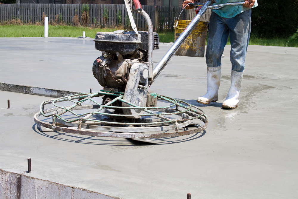 Vakman is bezig met het vlinderen van een betonvloer